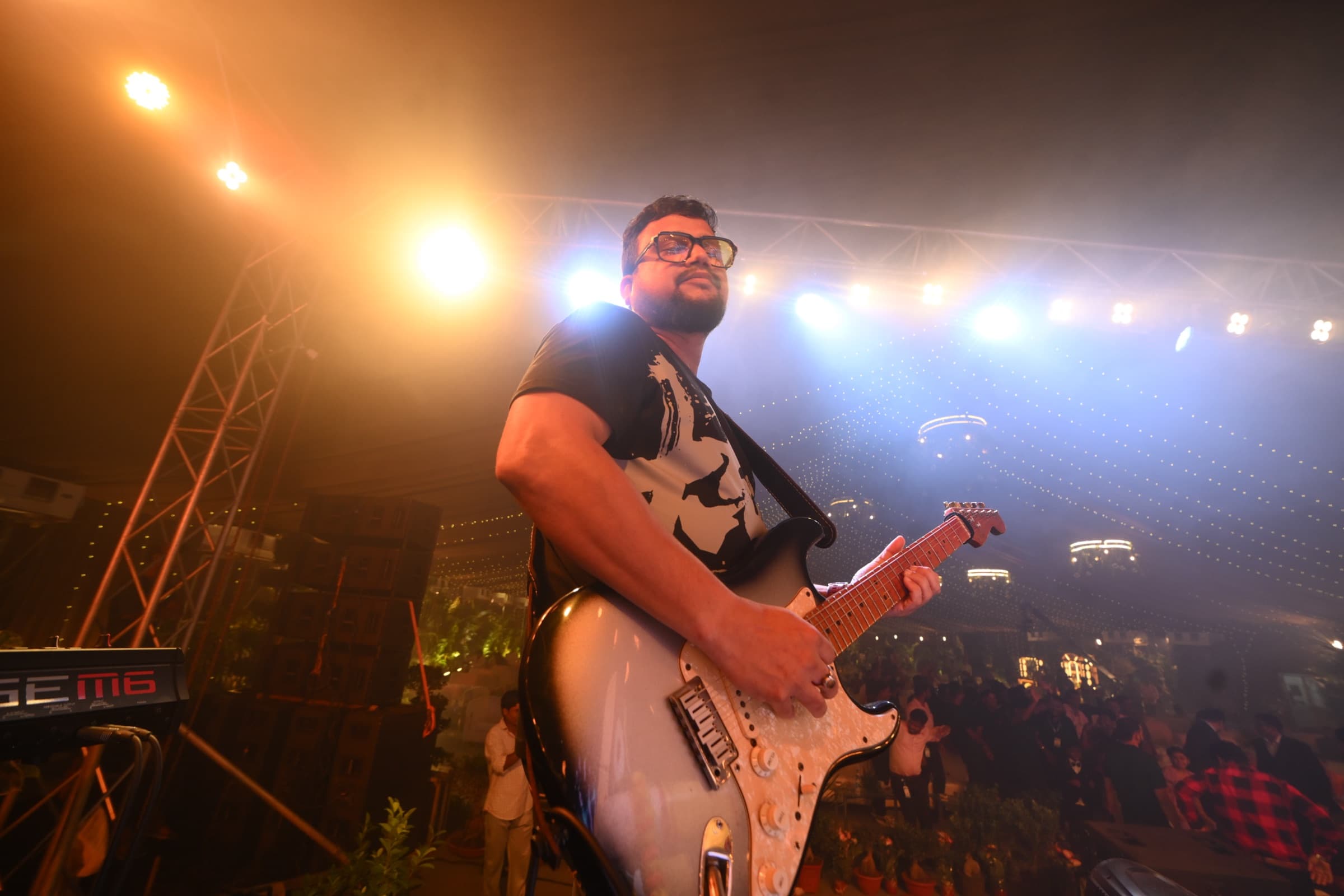 Guitarist performing live under concert lighting