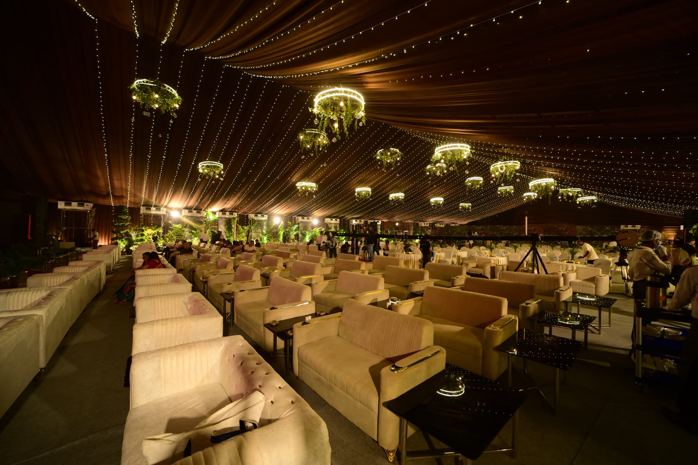Lounge seating styled with floral chandeliers and string lights